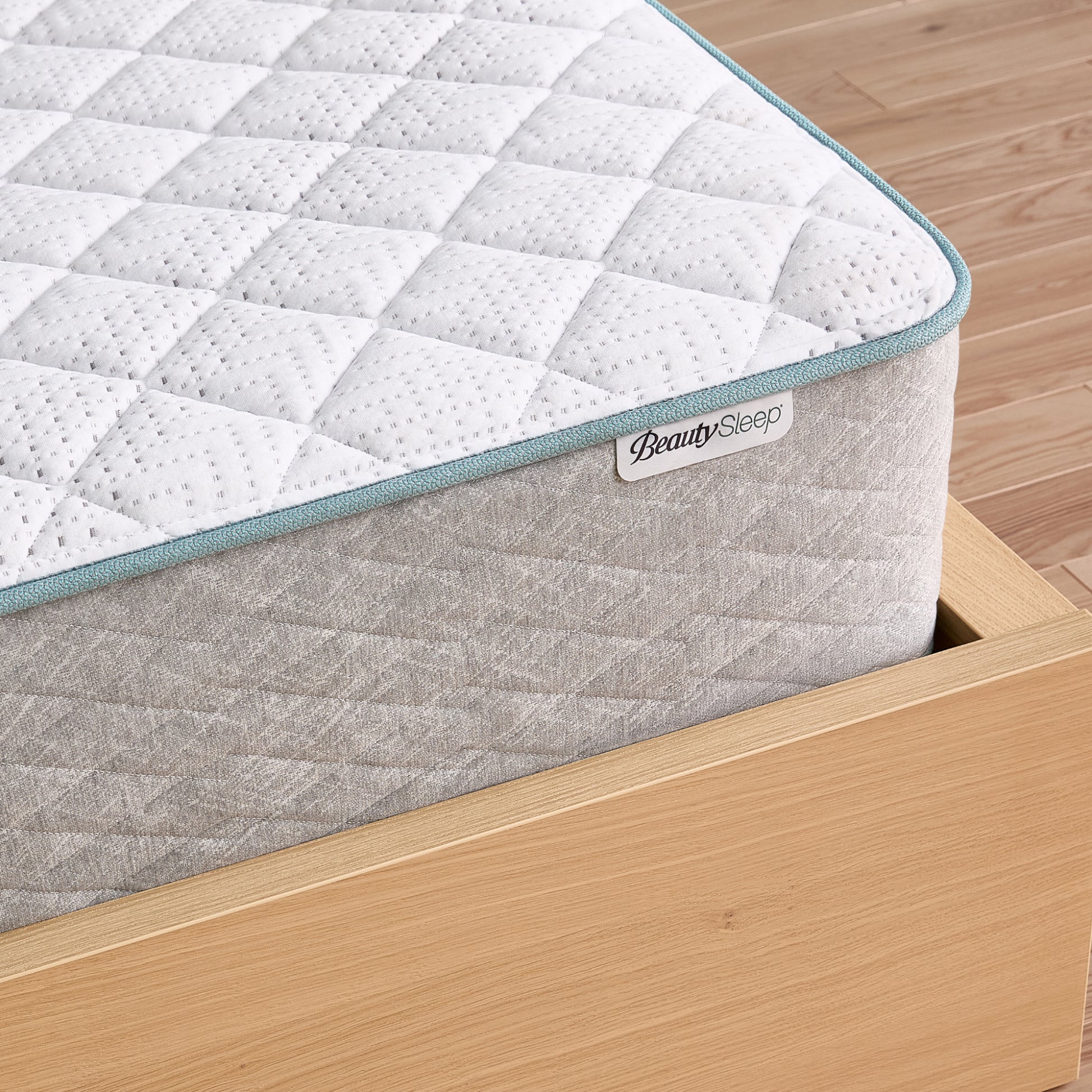 Mattress with BeautySleep branding on a wooden bed frame