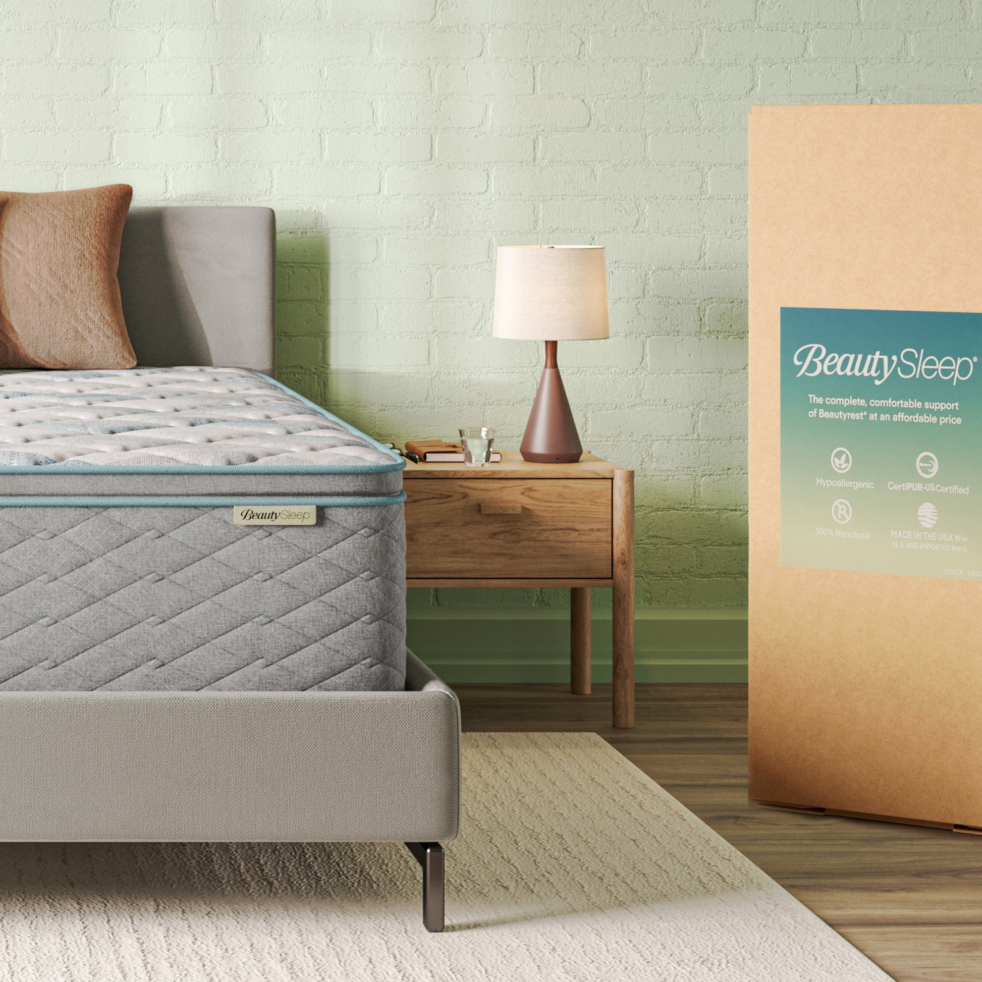 Gray mattress on a bed with a nightstand and lamp in a bedroom setting, featuring BeautySleep branding.
