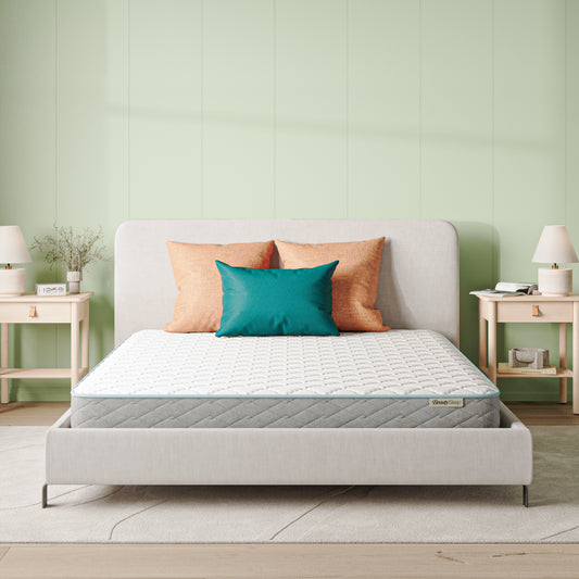 Beauty Sleep Mattress on a bed with decorative pillows in a bedroom setting